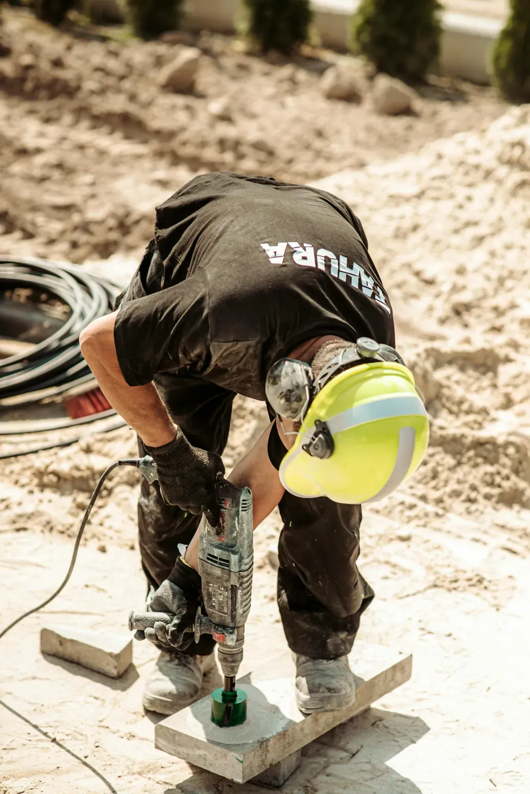 Bauarbeiter mit Bohrhammer auf einer Terrassenbaustelle